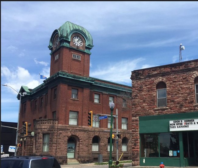 The historic clock tower and neighbouring stone storefronts in downtown Sault Ste. Marie